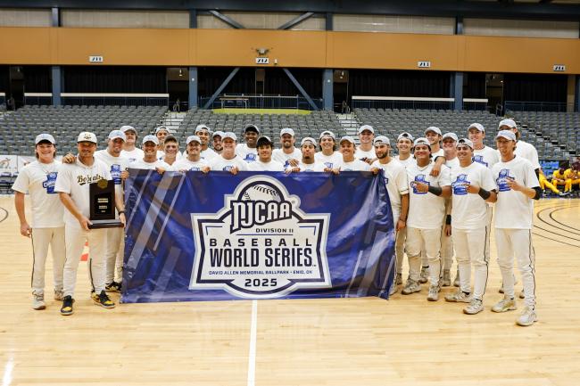 Baseball team pose with trophy at World Series Championship.